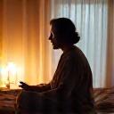 Person performing a relaxing pre-sleep ritual, such as reading a book in a calming environment with soft lighting, illustrating good sleep hygiene.